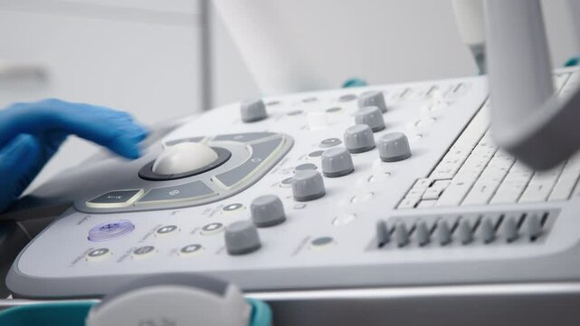 The hands of an ultrasound diagnostician on the control panel of an ultrasound machine during the examination. The concept of modern technology and advanced methods in medical imaging.