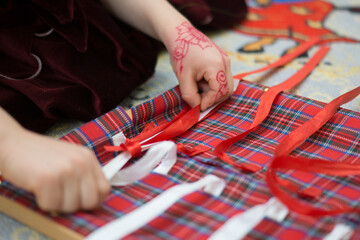 Focused Child Engaging in Creative Ribbon Threading Activity