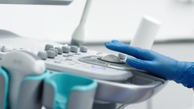 The hands of an ultrasound diagnostician on the control panel of an ultrasound machine during the examination. The concept of modern technology and advanced methods in medical imaging.
