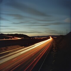 A light trail from a moving vehicle on a highway at night. Job ID: ea6270b7-1936-4159-be2f-a49901117e41