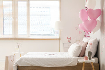 Interior of light bedroom with cozy bed and heart-shaped balloons. Valentine's Day celebration