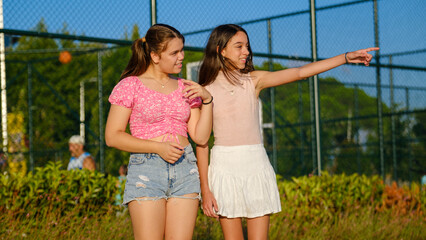 Two teenage girls friends, one slightly overweight and the other with dark skin, having a great...
