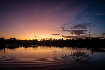 Night giving way to day above a a parkland pond
