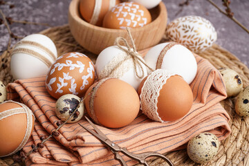 Braided mat with festive Easter eggs on grunge background, closeup