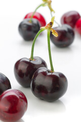 Fresh cherries arranged on a white background with vibrant red and dark purple hues