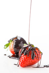 Strawberries drizzled with chocolate sauce on a white background