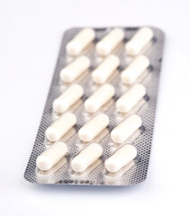 White capsules arranged in a blister pack on a neutral background for healthcare context