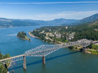 Aerial view of theBridge Of The Gods spanning the Columbia River. A scenic landscape of lush greenery and a tranquil waterway.  Cascade Locks, Oregon, USA