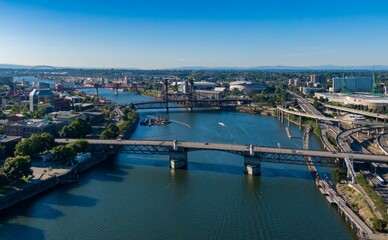 Obraz premium Aerial view of Portland, OR, showcasing the Willamette River, bridges, and city skyline. Urban landscape with transportation infrastructure. Portland, Oregon, USA