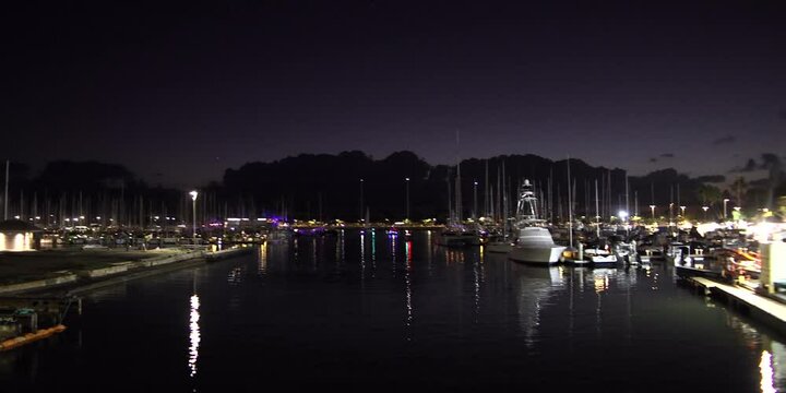 Harbor canal at night with boats in Hawaii, anamorphic