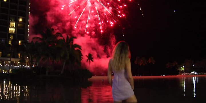 A woman watching close on a fireworks, anamorphic lens