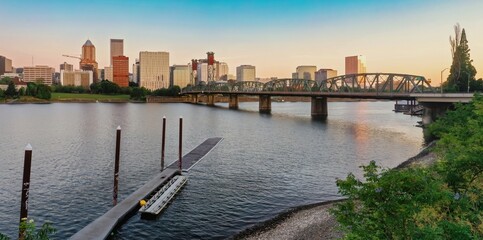 Naklejka premium Portland, OR skyline at dusk, Willamette River, and a small boat dock. City views, tranquil water, and a historic Hawthorne Bridge. Portland, Oregon, USA