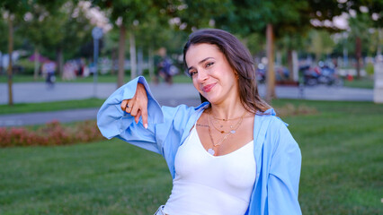 A young, beautiful brown-haired businesswoman is pointing to a corner of the screen with her index...