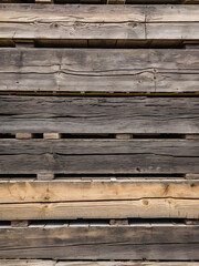 Close up of a wooden pallet, showing the details of its construction. The pallet is made of rough hewn planks and has a rustic appearance.