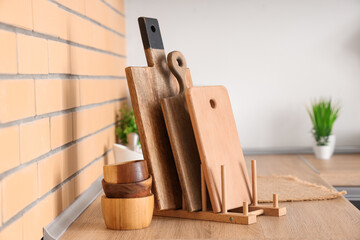 Cutting board and wooden bowls on table in kitchen, closeup