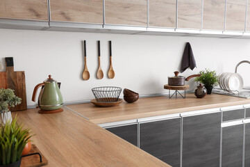 Houseplants and utensils on counter in kitchen