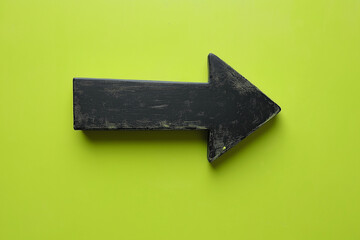 Fototapeta premium Black directional arrow isolated on a neon green background