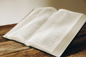 Fototapeta premium Open Holy Bible in English language on wooden table, closeup