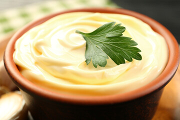 Delicious mayonnaise sauce with parsley in bowl on table, closeup