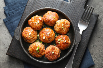 Tasty meatballs served on grey table, flat lay