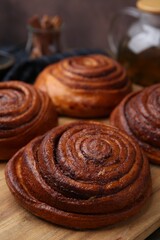 Delicious cinnamon rolls on wooden board, closeup