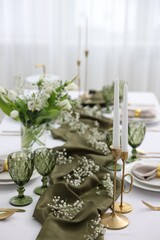 Color accent table setting with glasses, flowers and olive napkins