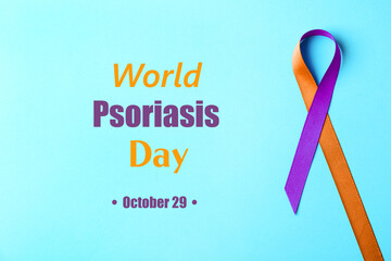 World Psoriasis Day (October, 29). Orange-orchid awareness ribbon on light blue background, top view