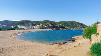 Playa de Tossa de Mar una ciudad tur&iacute;stica mediterr&aacute;nea, un d&iacute;a soleado con cielo azul y nubes. Desde Gerona, Catalu&ntilde;a, Espa&ntilde;a, Europa.