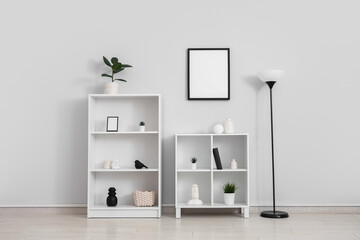 Shelving units and floor lamp near white wall in room