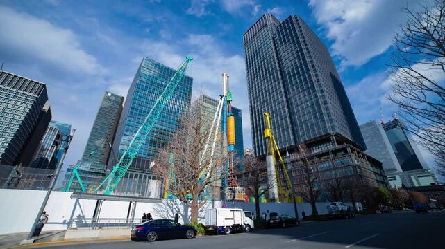 A timelapse of crane and traffic at the city crossing in Tokyo wide shot tilt