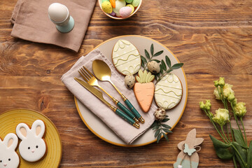 Beautiful table setting with sweet cookies, Easter eggs and eustoma flowers on wooden background
