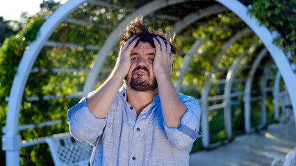 A middle-aged, dark-haired businessman wearing a shirt is looking at the camera with a defeated and...