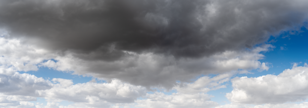 Panorama of a summer cloud filled sky fills the panorama with patches of blue,
