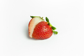 strawberries are arranged in a heart shape on a white background. The berries are red with green stems, some showing a transition to lighter, unripe areas. The image is a top-down view