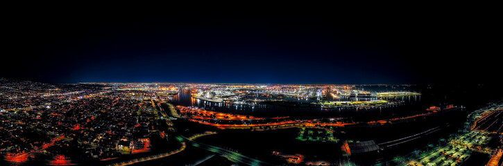 Panorama night photograph of the Port of Los Angeles, showing a wide angle covering city to sea