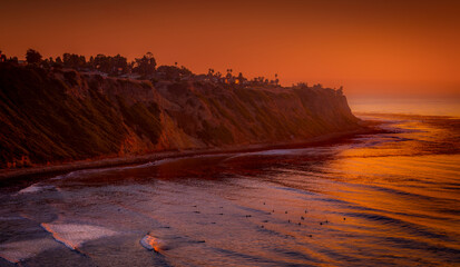 Bluff Cove, Palos Verdes Estates, surfers below wait for the next wave as the sky gives off...