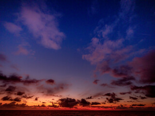 Dramatic skyscape slightly illuminates ocean and horizon and clouds slowly move in