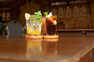 Close-up of refreshing drinks on a rustic wooden table, highlighting the vibrant colors and garnishes.