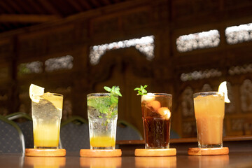 Close-up of refreshing drinks on a wooden table, highlighting the vibrant colors and garnishes.