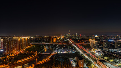 Obraz premium The night view of Beijing under China Zun in China, with the flow of vehicles and the lights from them