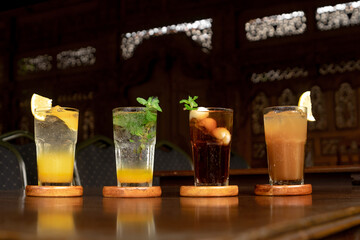 Aerial view of a variety of refreshing drinks on a wooden table, showcasing their arrangement and colors.