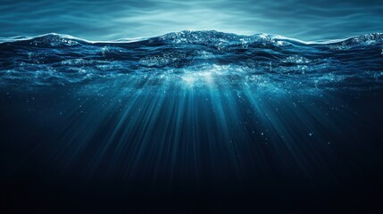 Fototapeta premium Underwater view of deep ocean, sunlight beams through surface.