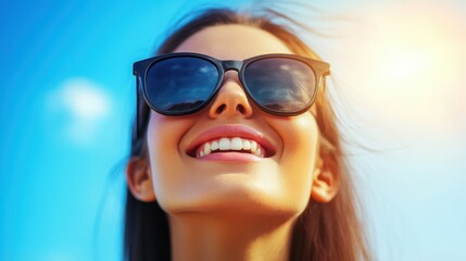 Fototapeta premium A cheerful woman in sunglasses gazes upward, basking in the sunlight and enjoying a bright, clear day.
