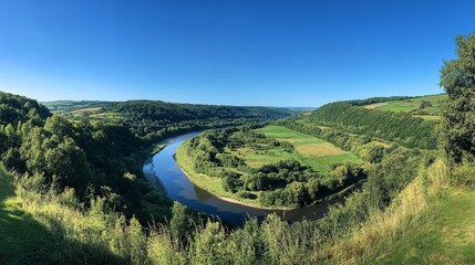 Fototapeta premium lush greenery and winding river against a clear blue sky