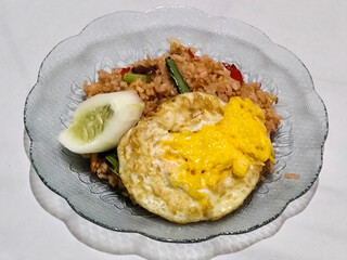 Fried rice, vegetables, crackers with fried egg as a side dish. Fried rice on a glass plate.