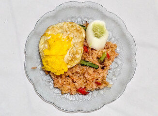 Fried rice, vegetables, crackers with fried egg as a side dish. Fried rice on a glass plate.