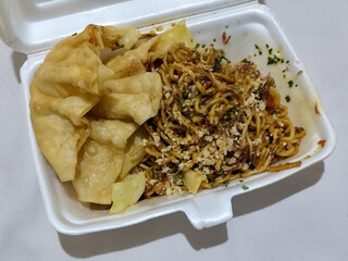 Mie Gacoan, Fried Noodles with a Typical Indonesian Spicy Level, served with Fried Dumplings, sprinkled with chicken and other toppings.