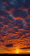Fototapeta premium Fiery Sunset Sky: A Dramatic Canvas of Crimson and Gold Vertical Wallpaper