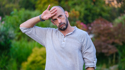 A handsome middle-aged businessman looks at the camera with a facial expression that clearly shows...