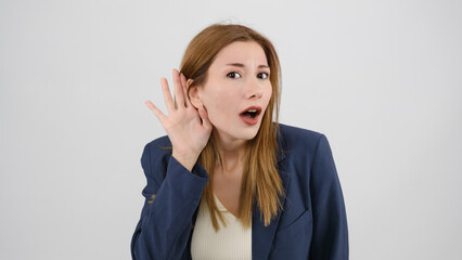 In a studio setting, a young businesswoman  s standing in front of a white background, placing her...